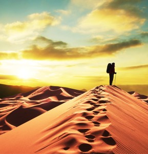 Man climbing a huge sand dune